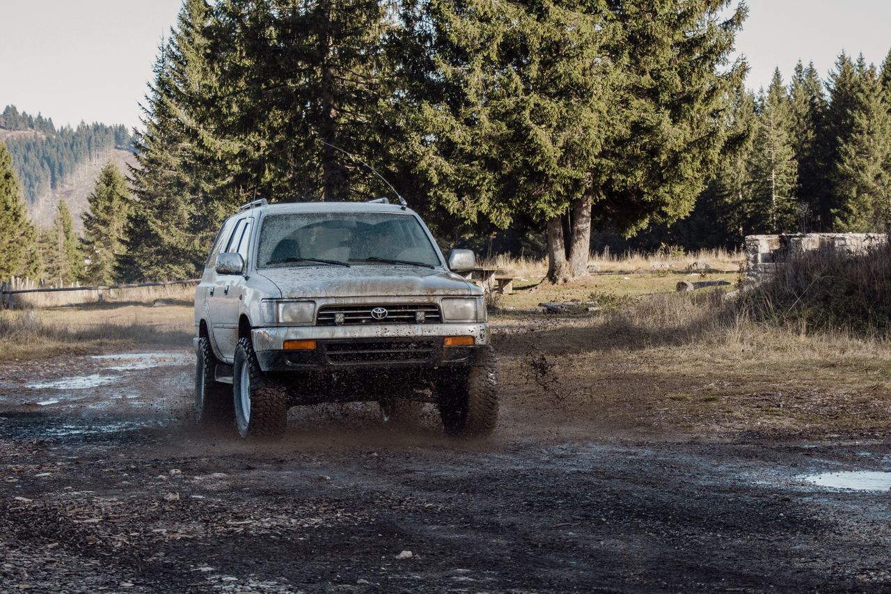 A rugged SUV tackles muddy terrain in the Veneto forest, capturing the spirit of adventure.